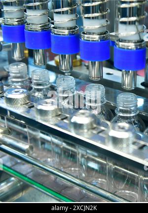 Kunststoffflaschen in einem Förderband auf einer hochwertigen automatischen vertikalen Abfüllmaschine. In der Produktionslinie des Werks Stockfoto