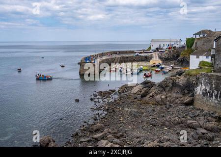 Das charmante kleine Fischerdorf Coverack an der südlichen Küste Cornwalls, England. Fischerboote liegen bei Ebbe im kleinen Hafen vor. Stockfoto