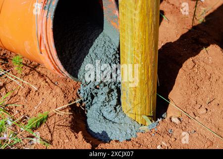 Betongießen neu installierter Holzzäunhölzer Stockfoto