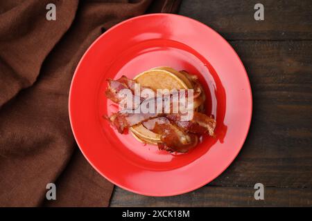 Köstliche Pfannkuchen mit Speck und Honig auf Holztisch, Blick von oben Stockfoto