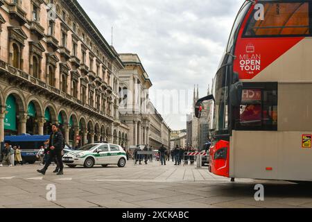 Touristenbus auf der Piazza del Duomo mit Polizisten, die den Platz, die Mailänder Kathedrale und die Galleria Vittorio Emanuele im Hintergrund, Mailand, Italien überprüfen Stockfoto