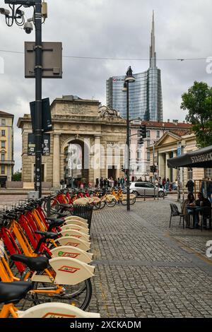 Eine Reihe von Fahrrädern zum Fahrradteilen mit dem antiken Stadttor Porta Garibaldi und dem Torre UniCredit, dem höchsten Wolkenkratzer in Italien, Mailand und der Lombardei Stockfoto