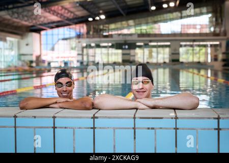Porträt von zwei jungen Frauen und Mannsportlern im Pool mit Schutzbrille Stockfoto