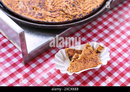 Socca, die gerade aus dem Ofen kommt, in Nizza, an der französischen Riviera. Socca ist eine Art dünner Socca, eine Spezialität der südöstlichen französischen Küche. Ein Pfannkuchen gemacht Stockfoto