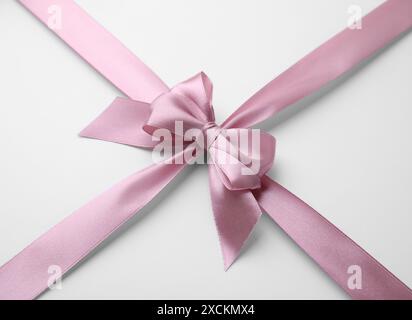 Rosa Satinband mit Bogen auf weißem Hintergrund Stockfoto