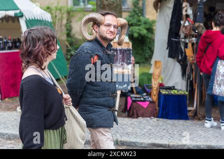 Berlin, Deutschland - 30. März 2024: Mittelaltermesse: Besucher des Ritterturniers. Ein junger Mann mit Widderhörnern auf dem Kopf, ein Schauspieler beim Ritter Stockfoto