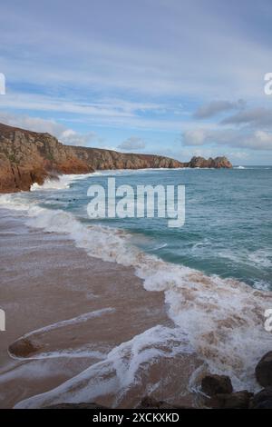 Surfer am Porthcurno Beach; Logan's Rock, Cornwall Stockfoto