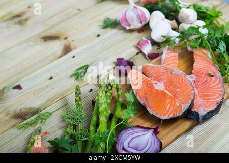 Gemüse, Lachssteaks, Pilze auf Holzgrund Stockfoto