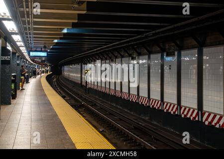 New York, NY – USA – 7. Juni 2024 Pendler treffen sich an der U-Bahn-Station Whitewall St South Ferry in Lower Manhattan und warten auf den nächsten R-Zug Stockfoto