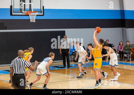 Ein Spieler aus Lakewood Park begeht eine Spurverletzung, als ein Blackhawk-Spieler einen Foul-Schuss in einem Basketballspiel in Auburn, Indiana, schießt. Stockfoto