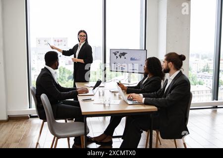 Geschäftsfrau, die sich vor Kollegen im modernen Büro präsentiert Stockfoto