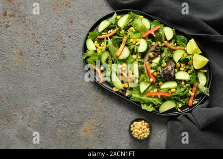 Teller mit frischem Gemüsesalat auf braunem Hintergrund Stockfoto
