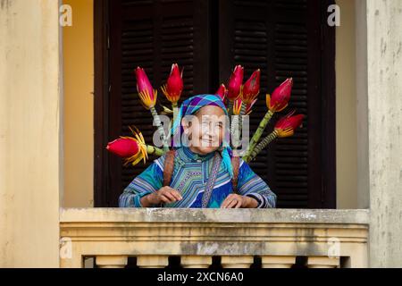 Blume Hmong Frau mit einem Korb mit Blumen im Hmong Königspalast (Vau Meo) in Bac Ha, Lao Cai Provinz, Vietnam Stockfoto