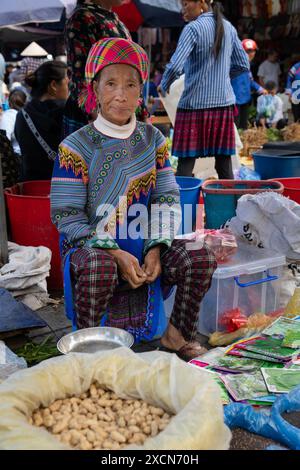 Hmong-Frau, die Lebensmittel auf dem Bac Ha Markt verkauft, Lao Cai Provinz, Vietnam Stockfoto