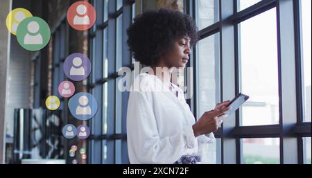 Bild von Social-Media-Ikonen über afroamerikanische Geschäftsfrau Stockfoto