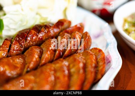 Im Norden Thailands gegrillte Wurst auf weißem Teller. Nordthailändische Würzige Wurst. Stockfoto