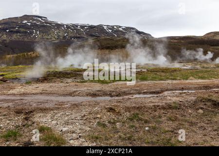 Geysir Geothermiegebiet im Haukadular-Tal, Island, mit dampfenden heißen Quellen, heißen Wasserbächen und Bergen im Hintergrund, keine Menschen. Stockfoto