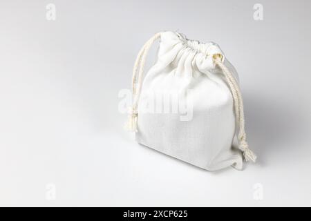 Kleiner Öko-Sack, Calico Canvas-Tasche mit Kordelzug, Modell eines kleinen Öko-Sacks aus natürlichem Baumwollgewebe isoliert auf weißem Hintergrund. Stockfoto