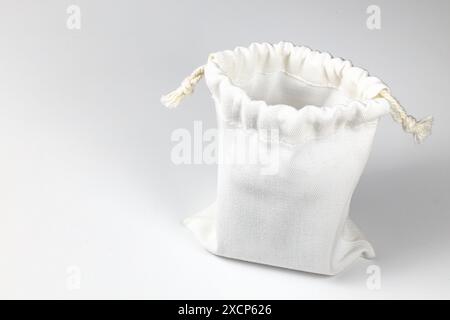 Kleiner Öko-Sack, Calico Canvas-Tasche mit Kordelzug, Modell eines kleinen Öko-Sacks aus natürlichem Baumwollgewebe isoliert auf weißem Hintergrund. Stockfoto