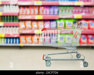 Waschmittelregale im Supermarkt oder Lebensmittelgeschäft mit leerem Einkaufswagen Stockfoto