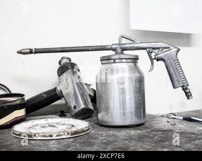 Lackierpistole auf Holztisch im Kfz-Reparaturzentrum Stockfoto