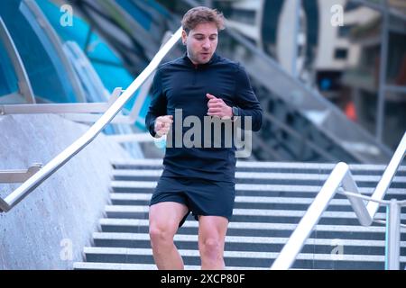 Athleten-Fitnesstraining, das Treppen hinunter läuft und dynamische Übungen im Freien macht. Stockfoto