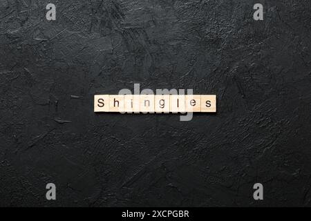 Schindeln Wort auf Holzblock geschrieben. Schindeln Text auf Zementtisch für Ihr Design, Konzept. Stockfoto