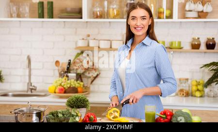 Frau, die in der modernen Küche Pfeffer hackt Stockfoto