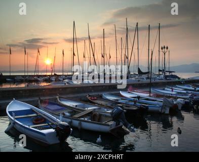 REISEBIBLIOTHEK VON KÜSTE ZU KÜSTE - VERWALTET VON PPL PHOTO AGENCY   COPYRIGHT RESERVIERT Ein Sonnenuntergang in Bardolino mit Fischerbooten und Yachten, die im Har vertäut sind Stockfoto