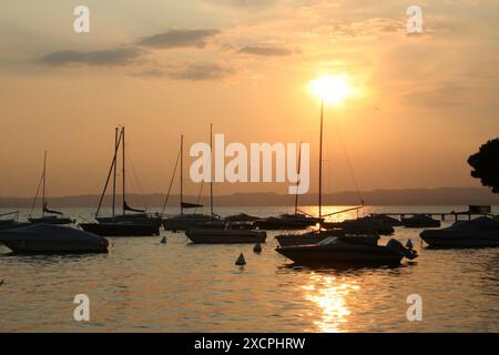 REISEBIBLIOTHEK VON KÜSTE ZU KÜSTE - VERWALTET VON PPL PHOTO AGENCY   COPYRIGHT RESERVIERT Ein Sonnenuntergang in Bardolino mit Yachten, die im Hafen am Gardasee vertäut sind Stockfoto