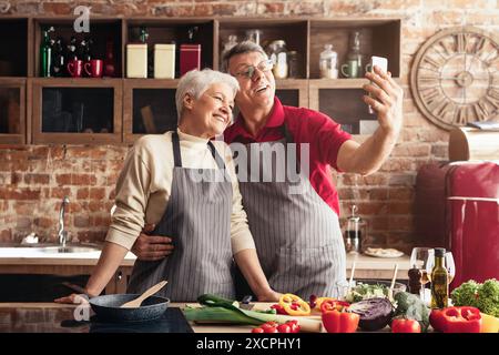 Glückliches Paar, das Selfie in Restaurant Kitchen nimmt Stockfoto