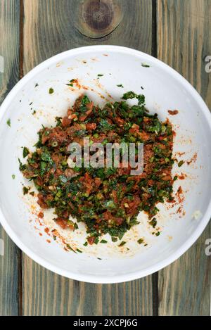 Gremolata-Gewürz aus fein gehackter Petersilie, zerdrücktem Knoblauch, sonnengetrockneten Tomaten und Minzblättern. Hausmannskost. Stockfoto