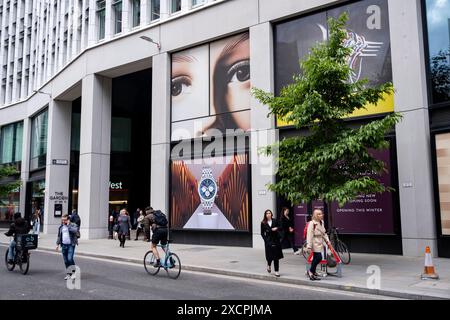 Passanten interagieren mit einem riesigen Gesicht mit Blick auf die Fenchurch Street über einem großformatigen Werbeplakat für die Luxusuhrenmarke Breitling in der City of London am 11. Juni 2024 in London, Großbritannien. Die Atmosphäre besteht darin, dass man beobachtet wird und dass Big Brother Sie beobachtet. Die City of London ist eine Stadt, ein zeremonielles County und ein lokaler Regierungsbezirk, der den Hauptgeschäftsbezirk von London umfasst. Die City of London wird allgemein als „Square Mile“ bezeichnet. Stockfoto