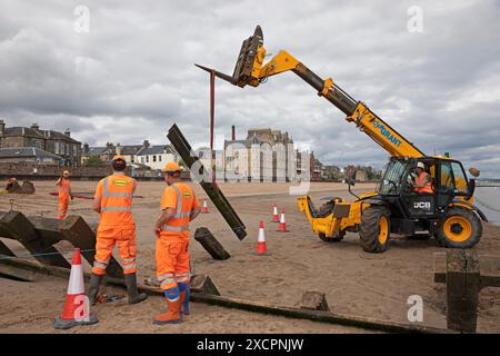 Portobello, Edinburgh, Schottland, Großbritannien. 18. Juni 2024. Am Montag, den 17. Juni, wurde mit der Instandsetzung des abgestürzten Abschnitts der Strandgroyne Nr. 4 begonnen. Außerdem werden die notwendigen Reparaturen an den restlichen Sträuchern 1-5 innerhalb der für die Arbeiten vorgesehenen 12 Wochen abgeschlossen. November 2021. Der Holzstrand Groyne Nummer 4 wurde durch Sturm Arwen zerstört und ließ einen Teil davon in einem Winkel von etwa 45 Grad zurück, nachdem die wilden Wellen, die über Nacht mit ihm zusammengetroffen sein müssen, in einem traurigen Zustand. Quelle: Arch White/Alamy Live News. Stockfoto