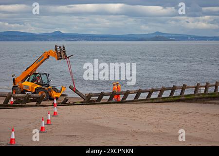 Portobello, Edinburgh, Schottland, Großbritannien. 18. Juni 2024. Am Montag, den 17. Juni, wurde mit der Instandsetzung des abgestürzten Abschnitts der Strandgroyne Nr. 4 begonnen. Außerdem werden die notwendigen Reparaturen an den restlichen Sträuchern 1-5 innerhalb der für die Arbeiten vorgesehenen 12 Wochen abgeschlossen. November 2021. Der Holzstrand Groyne Nummer 4 wurde durch Sturm Arwen zerstört und ließ einen Teil davon in einem Winkel von etwa 45 Grad zurück, nachdem die wilden Wellen, die über Nacht mit ihm zusammengetroffen sein müssen, in einem traurigen Zustand. Quelle: Arch White/Alamy Live News. Stockfoto