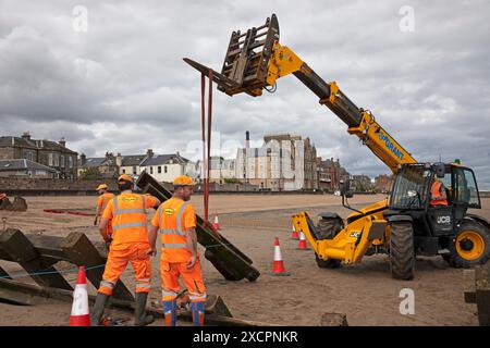 Portobello, Edinburgh, Schottland, Großbritannien. 18. Juni 2024. Am Montag, den 17. Juni, wurde mit der Instandsetzung des abgestürzten Abschnitts der Strandgroyne Nr. 4 begonnen. Außerdem werden die notwendigen Reparaturen an den restlichen Sträuchern 1-5 innerhalb der für die Arbeiten vorgesehenen 12 Wochen abgeschlossen. November 2021. Der Holzstrand Groyne Nummer 4 wurde durch Sturm Arwen zerstört und ließ einen Teil davon in einem Winkel von etwa 45 Grad zurück, nachdem die wilden Wellen, die über Nacht mit ihm zusammengetroffen sein müssen, in einem traurigen Zustand. Quelle: Arch White/Alamy Live News. Stockfoto