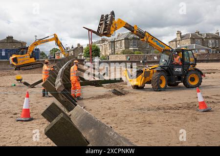 Portobello, Edinburgh, Schottland, Großbritannien. 18. Juni 2024. Am Montag, den 17. Juni, wurde mit der Instandsetzung des abgestürzten Abschnitts der Strandgroyne Nr. 4 begonnen. Außerdem werden die notwendigen Reparaturen an den restlichen Sträuchern 1-5 innerhalb der für die Arbeiten vorgesehenen 12 Wochen abgeschlossen. November 2021. Der Holzstrand Groyne Nummer 4 wurde durch Sturm Arwen zerstört und ließ einen Teil davon in einem Winkel von etwa 45 Grad zurück, nachdem die wilden Wellen, die über Nacht mit ihm zusammengetroffen sein müssen, in einem traurigen Zustand. Quelle: Arch White/Alamy Live News. Stockfoto