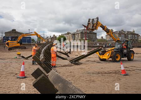 Portobello, Edinburgh, Schottland, Großbritannien. 18. Juni 2024. Am Montag, den 17. Juni, wurde mit der Instandsetzung des abgestürzten Abschnitts der Strandgroyne Nr. 4 begonnen. Außerdem werden die notwendigen Reparaturen an den restlichen Sträuchern 1-5 innerhalb der für die Arbeiten vorgesehenen 12 Wochen abgeschlossen. November 2021. Der Holzstrand Groyne Nummer 4 wurde durch Sturm Arwen zerstört und ließ einen Teil davon in einem Winkel von etwa 45 Grad zurück, nachdem die wilden Wellen, die über Nacht mit ihm zusammengetroffen sein müssen, in einem traurigen Zustand. Quelle: Arch White/Alamy Live News. Stockfoto