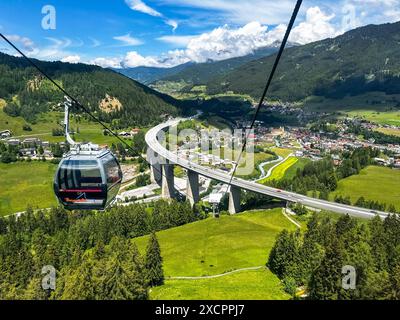 Das Foto zeigt eine Seilbahn Bergbahnen Bergeralm über dem Wipptal in Tirol, Österreich, mit Blick auf Steinach am Brenner. Die Seilbahn schwebt über eine grüne, alpine Landschaft mit dichten Wäldern und Wiesen, unter der sich die Brennerautobahn A13 und die Brennerbahn schlängeln. Der Hintergrund zeigt die beeindruckende Bergkulisse der Alpen. *** Das Foto zeigt eine Bergbahnen Bergeralm oberhalb des Wipptals in Tirol, Österreich, mit Blick auf Steinach am Brenner die Seilbahn schwingt über eine grüne, alpine Landschaft mit dichten Wäldern und Wiesen, unter denen die Brennerautobahn A13 und die Brennerautobahn A13 und die Bergbahn Stockfoto