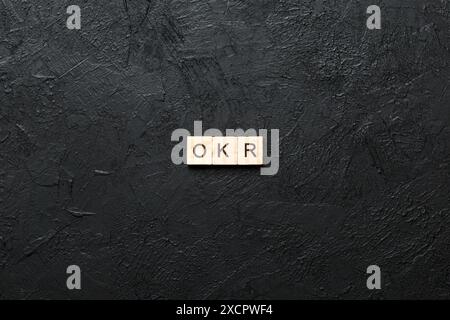 OKR Wort geschrieben auf Holzblock. Abkürzung für Objective Key Results Text auf Zementtabelle für Ihr Design, Konzept. Stockfoto