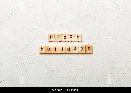Frohe Feiertage Wort auf Holzblock geschrieben. Happy Holidays Text auf Zementtisch für Ihr Design, Konzept. Stockfoto