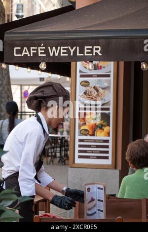 Mallorca, Spanien -30, März 2023. Eine Kellnerin in Uniform serviert einen Tisch im Café Sa Gelateria de Mallorca Stockfoto