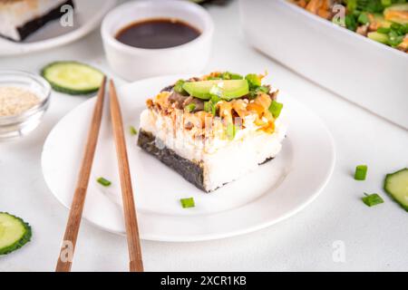 Philadelphia Sushi Bake Rezept Auflauf mit Reis, Frischkäse, Lachsforelle, Algen, Avocado, Soße, grüne Zwiebeln. Serviert mit geröstetem Nori-Sch Stockfoto