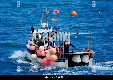 DIE ÄNDERUNG PER LINE AN BEN BIRCHALL-Premierminister Rishi Sunak (rechts) und den parlamentarischen Kandidaten der Konservativen für Torridge und Tavistock Sir Geoffrey Cox (links), während eines Besuchs in North Devon auf einem Boot im Hafen von Clovelly zu fahren, während sie Hummertöpfe sammeln, während der Wahlkampfspur der Wahl. Bilddatum: Dienstag, 18. Juni 2024. Stockfoto