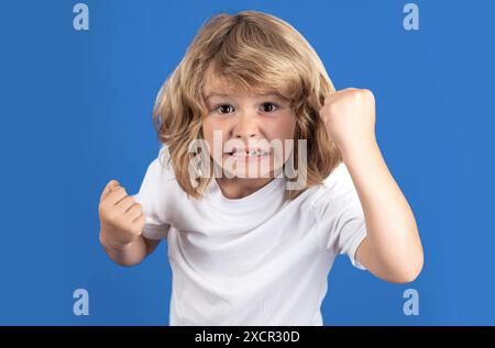 Kind mit wütendem Ausdruck im Studio. Wütender, hasserfüllter kleiner Junge, wütendes Kind. Wütende Wut, die Kinder sehen. Wütendes Kind mit wütender negativer Emotion Stockfoto