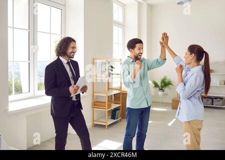 Glückliches Familienpaar, das Spaß hat, nachdem es sich um Immobilien handelt und ein neues Haus oder eine neue Wohnung gekauft hat Stockfoto