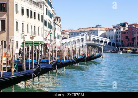 Gondeln, die entlang des Canale Grande mit Blick auf Rialto Brige und Touristen, San Polo, Venedig, Venetien, Italien vertäut sind Stockfoto