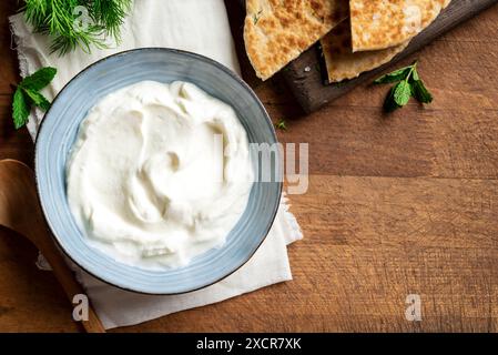 Hausgemachter Joghurt Labneh Käsedip und Pita-Brot für traditionelles nahöstliches, mediterranes Frühstück. Griechischer Joghurt in Schüssel, Draufsicht, Kopierraum. Stockfoto