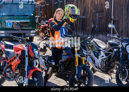 Radfahrer, der seinen Sicherheitshelm draußen auf seinem Motorrad befestigt Stockfoto