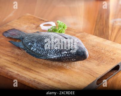 Roher Tilapia-Fisch auf einem Schneidebrett Stockfoto